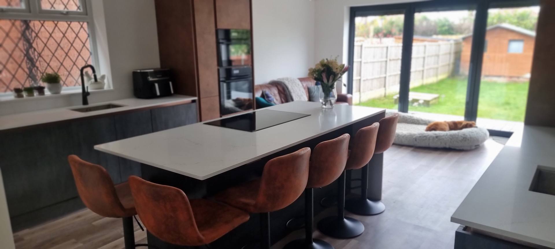White quartz island in a modern kitchen with seats in contrast brown